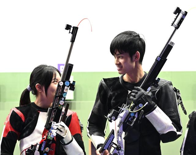 (260922) -- NAGOYA, Sept. 22, 2026 (Xinhua) -- Wang Zifei and Sheng Lihao (R) of team China react after the 10m air rifle mixed team final of shooting at the 20th Asian Games Aichi-Nagoya 2026 in Toyota of Aichi Prefecture, Japan, Sept. 22, 2026. (Xinhua/Liu Lei)