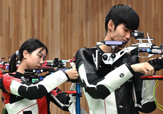 (260922) -- NAGOYA, Sept. 22, 2026 (Xinhua) -- Wang Zifei and Sheng Lihao (R) of team China react during the 10m air rifle mixed team final of shooting at the 20th Asian Games Aichi-Nagoya 2026 in Toyota of Aichi Prefecture, Japan, Sept. 22, 2026. (Xinhua/Liu Lei)