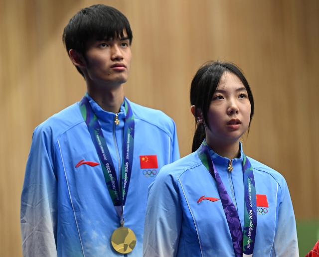 (260922) -- NAGOYA, Sept. 22, 2026 (Xinhua) -- Gold medalists Wang Zifei (R) and Sheng Lihao of team China react on the podium during the victory ceremony for the 10m air rifle mixed team of shooting at the 20th Asian Games Aichi-Nagoya 2026 in Toyota of Aichi Prefecture, Japan, Sept. 22, 2026. (Xinhua/Liu Lei)