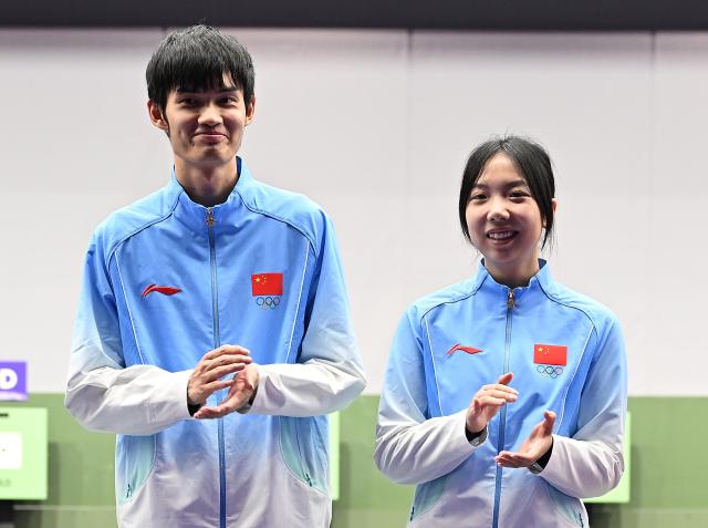 (260922) -- NAGOYA, Sept. 22, 2026 (Xinhua) -- Gold medalists Wang Zifei (R) and Sheng Lihao of team China clap hand during the victory ceremony for the 10m air rifle mixed team of shooting at the 20th Asian Games Aichi-Nagoya 2026 in Toyota of Aichi Prefecture, Japan, Sept. 22, 2026. (Xinhua/Liu Lei)
