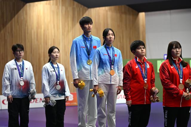 (260922) -- NAGOYA, Sept. 22, 2026 (Xinhua) -- Gold medalists team China (C), silver medalists team South Korea (L) and bronze medalists team Japan pose on the podium during the victory ceremony for the 10m air rifle mixed team of shooting at the 20th Asian Games Aichi-Nagoya 2026 in Toyota of Aichi Prefecture, Japan, Sept. 22, 2026. (Xinhua/Liu Lei)