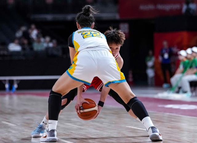 (260922) -- NAGOYA, Sept. 22, 2026 (Xinhua) -- Li Tsz Kwan (rear) of Hong Kong, China breaks through against Adelya Mustafina of Kazakhstan during the women's group B match between Hong Kong, China and Kazakhstan at 20th Asian Games Aichi-Nagoya 2026 in Nagoya, Japan, Sept. 22, 2026. (Xinhua/Luo Yuan)