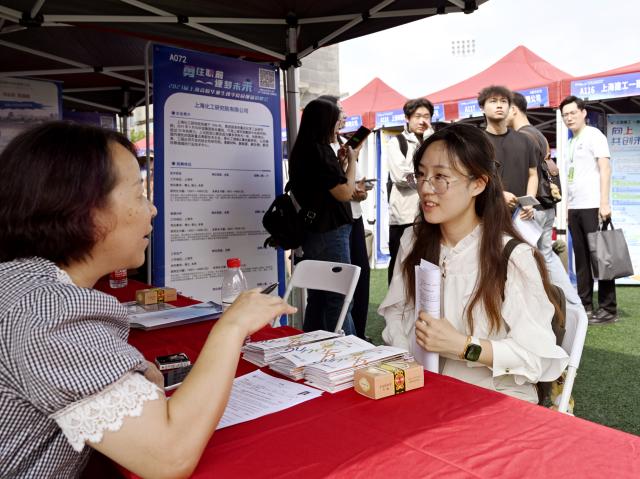 (260922) -- SHANGHAI, Sept. 22, 2026 (Xinhua) -- A graduate communicates with a recruiter during an autumn campus job fair for Shanghai university graduates at the East China Normal University in east China's Shanghai, Sept. 22, 2026. The job fair kicked off here on Tuesday, with the participation of nearly 1,000 employers, covering integrated circuits, biological medicine, artificial intelligence, finance, education and other fields. (Xinhua/Liu Ying)