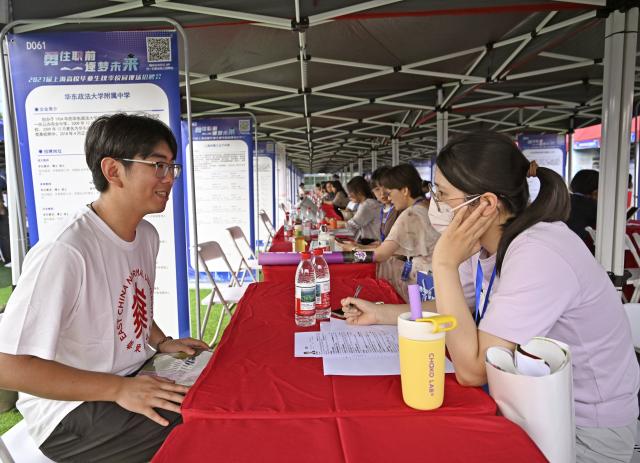 (260922) -- SHANGHAI, Sept. 22, 2026 (Xinhua) -- A graduate communicates with a recruiter during an autumn campus job fair for Shanghai university graduates at the East China Normal University in east China's Shanghai, Sept. 22, 2026. The job fair kicked off here on Tuesday, with the participation of nearly 1,000 employers, covering integrated circuits, biological medicine, artificial intelligence, finance, education and other fields. (Xinhua/Liu Ying)