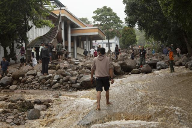 (260922) -- WEST SUMATRA, Sept. 22, 2026 (Xinhua) -- People are pictured on a muddy road after a flash flood in Solok district, West Sumatra, Indonesia, Sept. 22, 2026. At least one person was killed and four others were injured after a flash flood struck Solok district in Indonesia's West Sumatra province, local authorities said Tuesday. (Photo by Andri Mardiansyah/Xinhua)