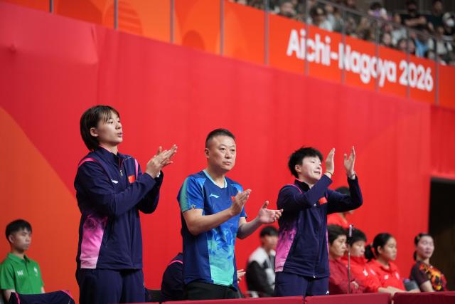 (260922) -- TOYOTA, Sept. 22, 2026 (Xinhua) -- Coach of China Ma Lin (C), player Chen Yi (L) and Fan Shulan applaud during the women's team quarterfinal match between China and Uzbekistan at the 20th Asian Games Aichi-Nagoya 2026 in Toyota, Japan, Sept. 22, 2026. (Xinhua/Cheong Kam Ka)