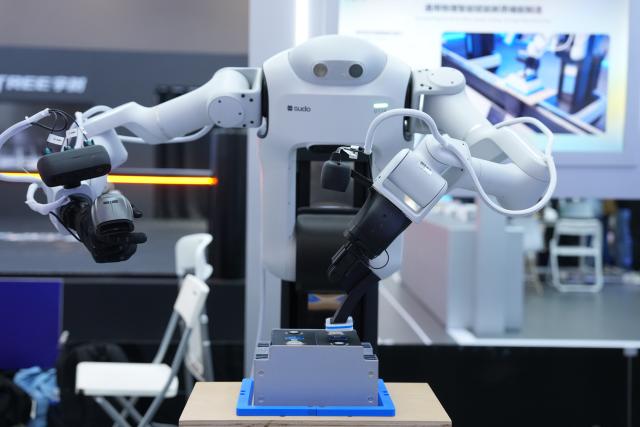 (260922) -- HANGZHOU, Sept. 22, 2026 (Xinhua) -- A humanoid robot demonstrates assembly and production in a simulated workshop scenario during the 2026 Apsara Conference in Hangzhou, east China's Zhejiang Province, Sept. 22, 2026. The 2026 Apsara Conference opened here on Tuesday, and will last for three days. The conference has three main forums and more than 120 sub-forums. (Xinhua/Huang Zongzhi)