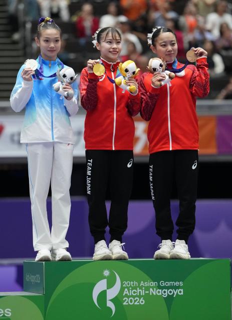 (260922) -- NAGOYA, Sept. 22, 2026 (Xinhua) -- Gold medalist Sugihara Aiko (C) of Japan, silver medalist Ke Qinqin (L) of China and bronze medalist Nishiyama Misa of Japan pose for photos during the awarding ceremony for the artistic gymnastics women's all-around final at the 20th Asian Games Aichi-Nagoya 2026 in Nagoya, Japan, Sept. 22, 2026. (Xinhua/Lui Siu Wai)