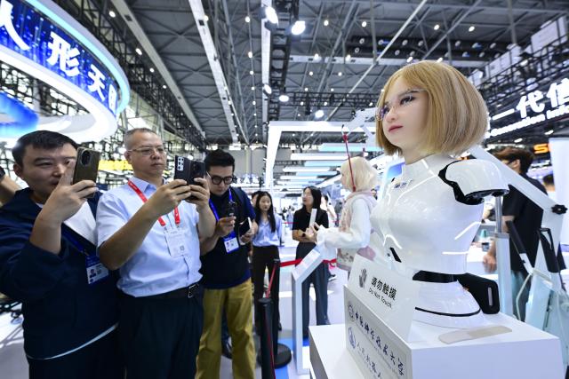 (260922) -- HEFEI, Sept. 22, 2026 (Xinhua) -- Visitors take photos of a humanoid robot at the 2026 World Manufacturing Convention (WMC) in Hefei, east China's Anhui Province, Sept. 21, 2026. The ongoing 2026 WMC showcases wide-ranging applications of robots. (Xinhua/Zhou Mu)