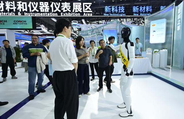 (260922) -- HEFEI, Sept. 22, 2026 (Xinhua) -- A humanoid robot introduces products to visitors at the 2026 World Manufacturing Convention (WMC) in Hefei, east China's Anhui Province, Sept. 21, 2026. The ongoing 2026 WMC showcases wide-ranging applications of robots. (Xinhua/Zhou Mu)