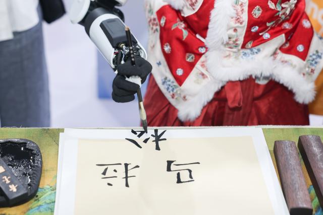 (260922) -- HEFEI, Sept. 22, 2026 (Xinhua) -- A robot writes calligraphy at the 2026 World Manufacturing Convention (WMC) in Hefei, east China's Anhui Province, Sept. 20, 2026. The ongoing 2026 WMC showcases wide-ranging applications of robots. (Xinhua/Chang Nengjia)