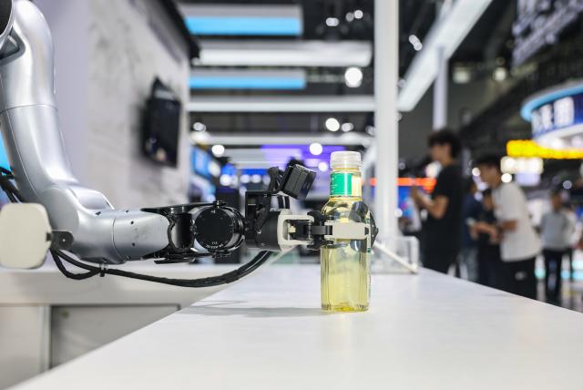 (260922) -- HEFEI, Sept. 22, 2026 (Xinhua) -- A robot delivers a bottled beverage at the 2026 World Manufacturing Convention (WMC) in Hefei, east China's Anhui Province, Sept. 20, 2026. The ongoing 2026 WMC showcases wide-ranging applications of robots. (Xinhua/Chang Nengjia)