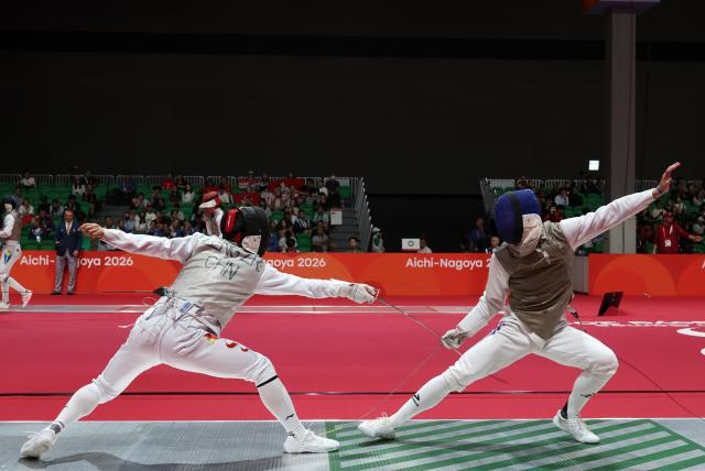(260922) -- TOKONAME, Sept. 22, 2026 (Xinhua) -- Zeng Zhaoran (L) of China competes against Daniil Kravtsov of Uzbekistan during the men's foil individual round of 16 match at the 20th Asian Games Aichi-Nagoya 2026 in Tokoname, Aichi Prefecture, Japan, Sept. 22, 2026. (Xinhua/Yao Qilin)