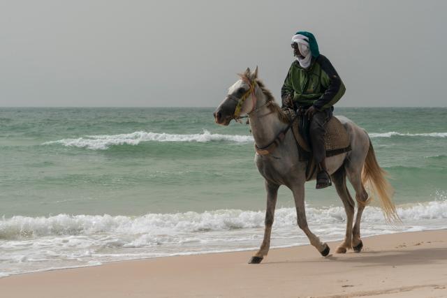 (260923) -- NOUAKCHOTT, Sept. 23, 2026 (Xinhua) -- A man rides a horse along a beach in Nouakchott, capital of Mauritania, Sept. 22, 2026. (Xinhua/Xie Jianfei)