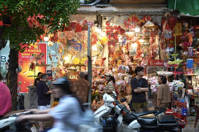 (260923) -- HANOI, Sept. 23, 2026 (Xinhua) -- People shop for lanterns and other decorations for the Mid-Autumn Festival at the Old Quarter in Hanoi, Vietnam, Sept. 22, 2026. A festive atmosphere is growing here as the Mid-Autumn Festival approaches. (Xinhua/Liu Ying)