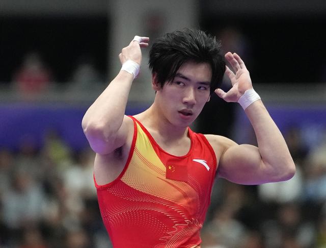 (260923) -- NAGOYA, Sept. 23, 2026 (Xinhua) -- Zhang Boheng of team China reacts after the floor exercise competition of men's team final of Artistic Gymnastics at the 20th Asian Games Aichi-Nagoya 2026 in Nagoya, Japan, Sept. 23, 2026. (Xinhua/Lui Siu Wai)