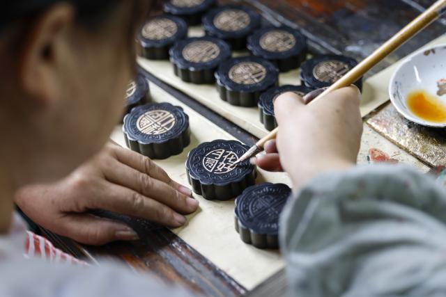 (260923) -- HUANGSHAN, Sept. 23, 2026 (Xinhua) -- A craftswoman makes a mooncake-shaped Hui ink stick at an ink workshop in Shexian County, Huangshan City, east China's Anhui Province, Sept. 9, 2026.
  The Hui ink sticks are primarily composed of the soot produced by burning pine trees or tung oil, with glue as the main ingredient, supplemented by various minerals and Chinese herbal ingredients in the formulation. It undergoes a meticulous crafting process involving dozens of steps.
  As the Mid-Autumn Festival approaches, local ink-making craftsmen shaped ink sticks into mooncake forms, giving the ancient craft a trendy way to greet the festival. (Photo by Shi Yalei/Xinhua)