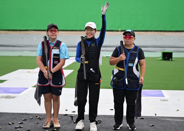 (260923) -- NAGOYA, Sept. 23, 2026 (Xinhua) -- Jiang Yiting (C) of China, Isarapa Imprasertsuk (L) of Thailand, Assem Orynbay of Kazakhstan pose for photos after the Skeet Women Individual Final of shooting at the 20th Asian Games Aichi-Nagoya 2026 in Toyota of Aichi Prefecture, Japan, Sept. 23, 2026. (Xinhua/Liu Lei)
