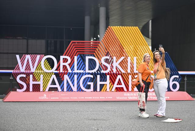 (260923) -- SHANGHAI, Sept. 23, 2026 (Xinhua) -- People pose for selfies at the National Exhibition and Convention Center, venue for the 48th WorldSkills Competition in east China's Shanghai, Sept. 23, 2026. The competition kicks off here on Wednesday. (Xinhua/Chen Haoming)
