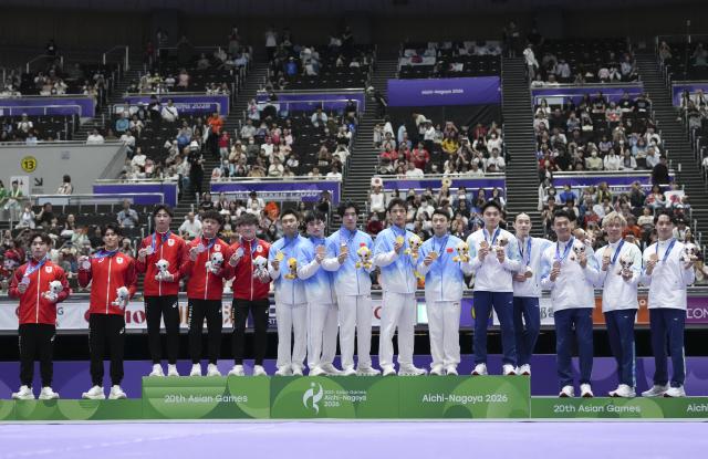(260923) -- NAGOYA, Sept. 23, 2026 (Xinhua) -- Gold medalist team China (C), silver medalist team Japan (L) and bronze medalist team Chinese Taipei pose during the awarding ceremony for men's team of Artistic Gymnastics at the 20th Asian Games Aichi-Nagoya 2026 in Nagoya, Japan, Sept. 23, 2026. (Xinhua/Jia Yuchen)