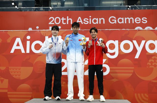 (260923) -- TOKYO, Sept. 23, 2026 (Xinhua) -- Gold medalist Zhang Zhanshuo (C) of China, silver medalist Hwang Sunwoo (L) of South Korea and bronze medalist Murasa Tatsuya of Japan pose during the awarding ceremony for the men's 200m freestyle at the 20th Asian Games Aichi-Nagoya 2026 in Tokyo, Japan, Sept. 23, 2026. (Xinhua/Wu Zhizun)
