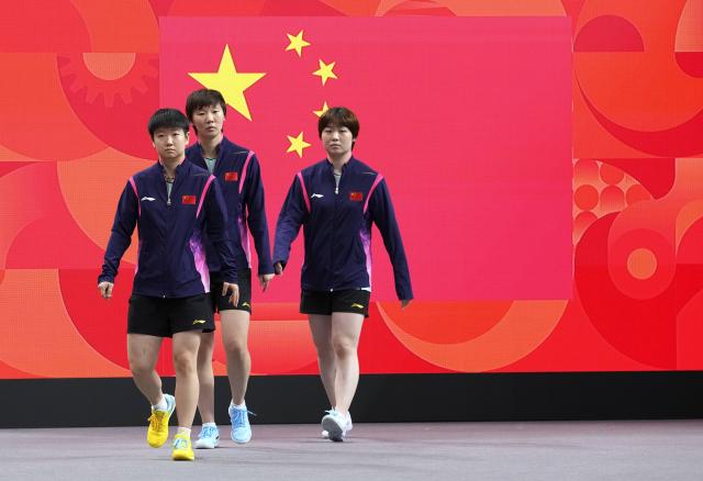 (260923) -- TOYOTA, Sept. 23, 2026 (Xinhua) -- Sun Yingsha (L), Wang Manyu (C) and Kuai Man of team China enter the arena during the women's team semifinal match between China and the Democratic People's Republic of Korea (DPRK) at the 20th Asian Games Aichi-Nagoya 2026 in Toyota of Aichi Prefecture, Japan, Sept. 23, 2026. (Xinhua/Cheong Kam Ka)
