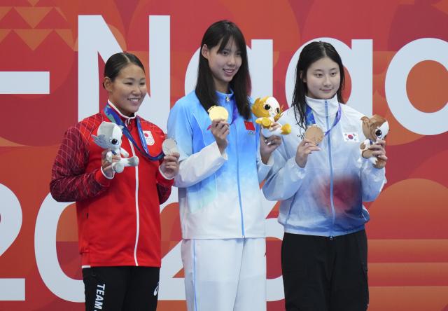 (260923) -- TOKYO, Sept. 23, 2026 (Xinhua) -- Gold medalist Peng Xuwei (C) of China, silver medalist Shirai Rio (L) of Japan and bronze medalist Kim Seungwon of South Korea pose during the awarding ceremony after the women's 100m backstroke final at the 20th Asian Games Aichi-Nagoya 2026 in Tokyo, Japan, Sept. 23, 2026. (Xinhua/Chen Zeguo)