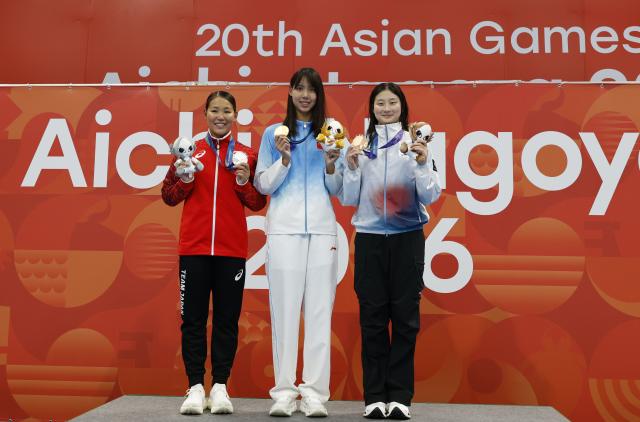 (260923) -- TOKYO, Sept. 23, 2026 (Xinhua) -- Gold medalist Peng Xuwei (C) of China, silver medalist Shirai Rio (L) of Japan and bronze medalist Kim Seungwon of South Korea pose during the awarding ceremony after the women's 100m backstroke final at the 20th Asian Games Aichi-Nagoya 2026 in Tokyo, Japan, Sept. 23, 2026. (Xinhua/Wu Zhizun)