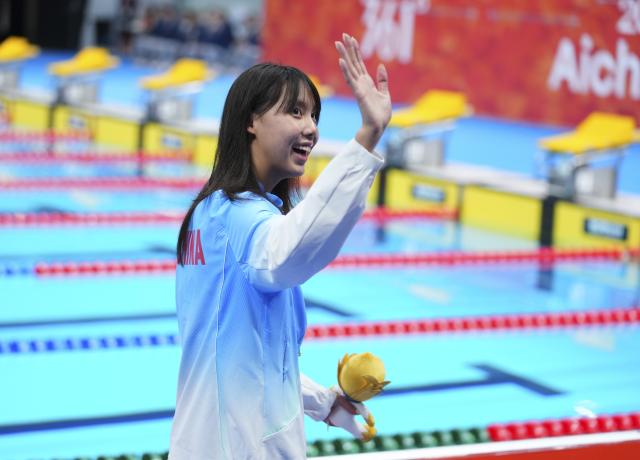 (260923) -- TOKYO, Sept. 23, 2026 (Xinhua) -- Gold medalist Peng Xuwei of China waves after the awarding ceremony after the women's 100m backstroke final at the 20th Asian Games Aichi-Nagoya 2026 in Tokyo, Japan, Sept. 23, 2026. (Xinhua/Chen Zeguo)