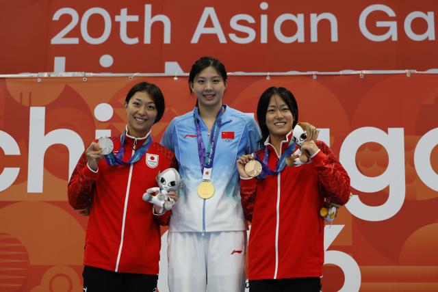 (260923) -- TOKYO, Sept. 23, 2026 (Xinhua) -- Gold medalist Tang Qianting (C) of China, Silver medalist Suzuki Satomi (L) of Japan and Bronze medalist Kato Kotomi of Japan pose during awarding ceremony for the women's 100m breaststroke at the 20th Asian Games Aichi-Nagoya 2026 in Tokyo, Japan, Sept. 23, 2026. (Xinhua/Wu Zhizun)