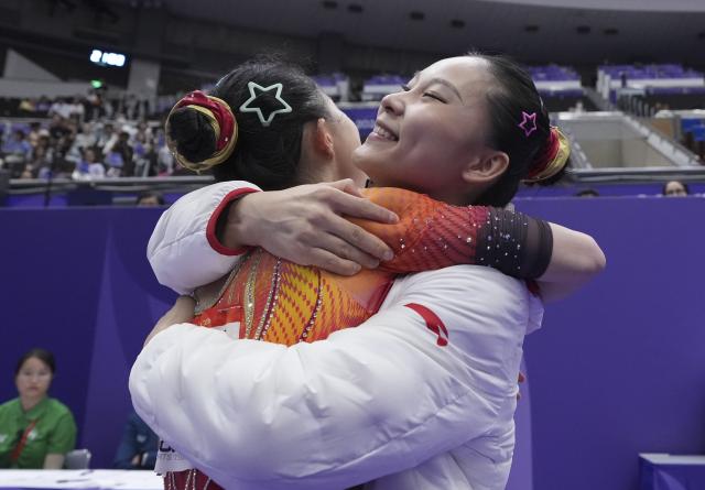 (260923) -- NAGOYA, Sept. 23, 2026 (Xinhua) -- Zhang Yihan (L) hugs with Du Siyu of China during floor exercise competition of the women's team final of Artistic Gymnastics at the 20th Asian Games Aichi-Nagoya 2026 in Nagoya, Japan, Sept. 23, 2026. (Xinhua/Jia Yuchen)