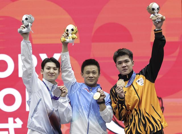(260923) -- NAGOYA, Sept. 23, 2026 (Xinhua) -- Gold medalist Gao Xiaobin (C) of China, silver medalist Lee Hasung (L) of South Korea and bronze medalist Ting Clement Su Wei of Malaysia pose for photos after the Men's Daoshu and Gunshu Final of Wushu at the 20th Asian Games Aichi-Nagoya 2026 in Nagoya, Japan, Sept. 23, 2026. (Xinhua/Long Lei)