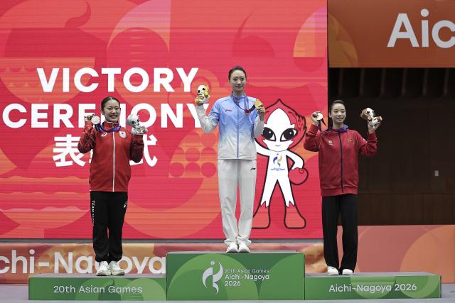(260923) -- NAGOYA, Sept. 23, 2026 (Xinhua) -- Gold Medalist Yao Yang (C) of China, silver medalist Kida Nanoha (L) of Japan and bronze medalist Duong Thuy Vi of Vietnam pose for photos during the awarding ceremony for the Women's Jianshu and Qiangshu Final of Wushu at the 20th Asian Games Aichi-Nagoya 2026 in Nagoya, Japan, Sept. 23, 2026. (Xinhua/Long Lei)