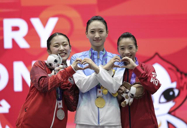 (260923) -- NAGOYA, Sept. 23, 2026 (Xinhua) -- Gold Medalist Yao Yang (C) of China, silver medalist Kida Nanoha (L) of Japan and bronze medalist Duong Thuy Vi of Vietnam pose for photos during the awarding ceremony for the Women's Jianshu and Qiangshu Final of Wushu at the 20th Asian Games Aichi-Nagoya 2026 in Nagoya, Japan, Sept. 23, 2026. (Xinhua/Long Lei)