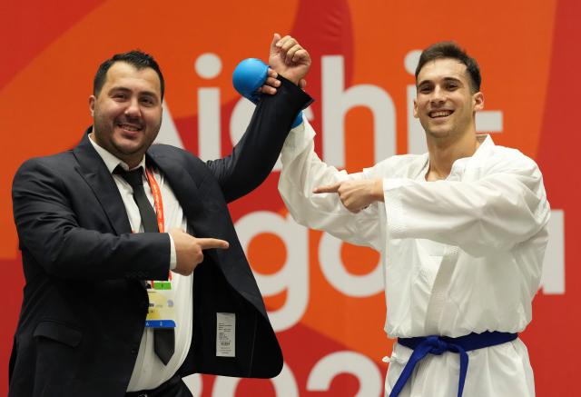 (260923) -- TOYOHASHI, Sept. 23, 2026 (Xinhua) -- Mahmoud Nemati (R) of Iran celebrates with his coach after defeating Sanad Hassan Y Sufyani of Saudi Arabia in the men's kumite +84kg final of Karate at the 20th Asian Games Aichi-Nagoya 2026 in Toyohashi of Aichi Prefecture, Japan, Sept. 23, 2026. (Xinhua/Wang Fei)