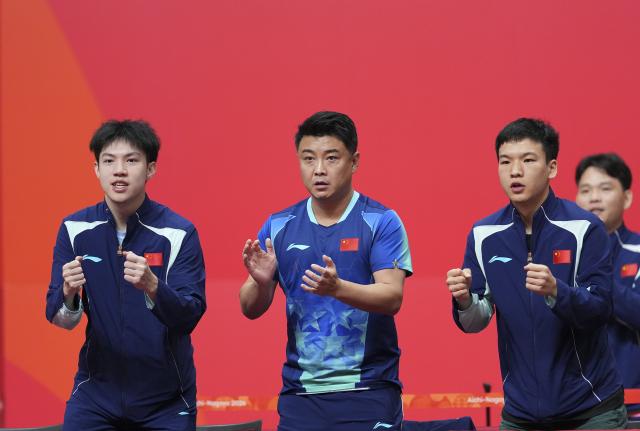 (260923) -- TOYOTA, Sept. 23, 2026 (Xinhua) -- Wang Hao (2nd L), coach of China, applauds for Wang Chuqin during his match against Lin Yun-ju of Chinese Taipei during the men's team semifinal match between China and Chinese Taipei at the 20th Asian Games Aichi-Nagoya 2026 in Toyota of Aichi Prefecture, Japan, Sept. 23, 2026. (Xinhua/Cheong Kam Ka)