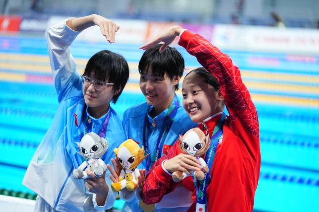 (260923) -- TOKYO, Sept. 23, 2026 (Xinhua) -- Gold medalist Yu Zidi (C) of China, Silver medalist Ke Wenxi (L) of China and Bronze medalist Narita Mio of Japan pose after the awarding ceremony after the women's 400m individual medley final at the 20th Asian Games Aichi-Nagoya 2026 in Tokyo, Japan, Sept. 23, 2026. (Xinhua/Chen Zeguo)