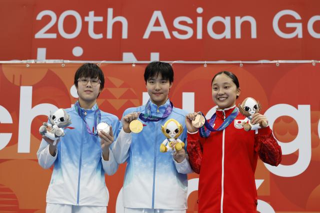 (260923) -- TOKYO, Sept. 23, 2026 (Xinhua) -- Gold medalist Yu Zidi (C) of China, Silver medalist Ke Wenxi (L) of China and Bronze medalist Narita Mio of Japan pose during the awarding ceremony after the women's 400m individual medley final at the 20th Asian Games Aichi-Nagoya 2026 in Tokyo, Japan, Sept. 23, 2026. (Xinhua/Wu Zhizun)