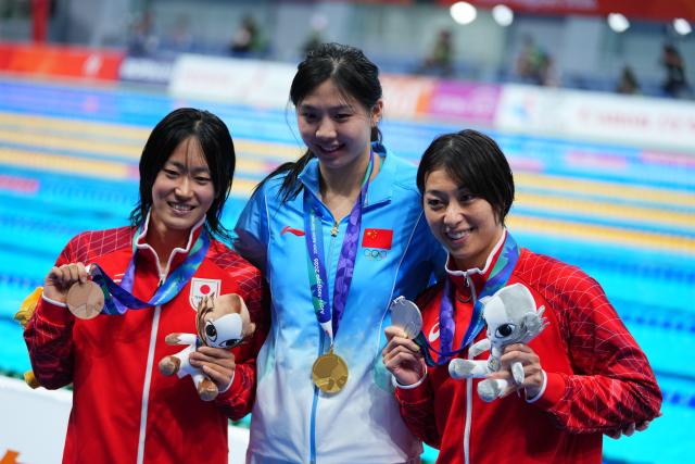 (260923) -- TOKYO, Sept. 23, 2026 (Xinhua) -- Gold medalist Tang Qianting (C) of China, Silver medalist Suzuki Satomi (R) of Japan and Bronze medalist Kato Kotomi of Japan pose after awarding ceremony for the women's 100m breaststroke final at the 20th Asian Games Aichi-Nagoya 2026 in Tokyo, Japan, Sept. 23, 2026. (Xinhua/Chen Zeguo)