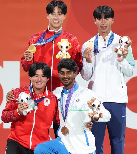 (260923) -- NAGOYA, Sept. 23, 2026 (Xinhua) -- Gold medalist Uematsu Toshiki (top L) of Japan, silver medalist Kurosaka Takuya (bottom L) of Japan, bronze medalists Chen Po-yi (top R) of Chinese Taipei and Jay Meena of India pose for photos during the awarding ceremony for the men's singles of soft tennis event at the 20th Asian Games Aichi-Nagoya 2026 in Nagoya, Japan, Sept. 23, 2026. (Xinhua/Deng Hua)