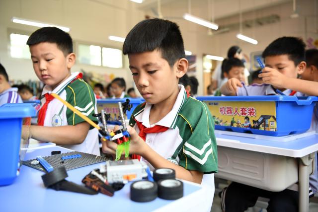 (260923) -- RIZHAO, Sept. 23, 2026 (Xinhua) -- Students practice assembling robots at a primary school in Juxian County, east China's Shandong Province, Sept. 23, 2026. A primary school in Juxian County has set up more than 60 student clubs in seven categories, enriching campus life for students and helping them achieve all-round development. (Xinhua/Guo Xulei)
