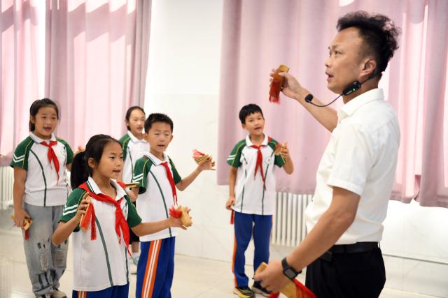 (260923) -- RIZHAO, Sept. 23, 2026 (Xinhua) -- Students practice clapper talk at a primary school in Juxian County, east China's Shandong Province, Sept. 23, 2026. A primary school in Juxian County has set up more than 60 student clubs in seven categories, enriching campus life for students and helping them achieve all-round development. (Xinhua/Guo Xulei)