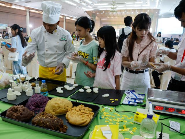(260924) -- YANGON, Sept. 24, 2026 (Xinhua) -- People make mooncakes during an event to celebrate the upcoming Mid-Autumn Festival in Yangon, Myanmar, Sept. 23, 2026. TO GO WITH "Asia-Pacific Community: Mooncakes, tea foster China-Myanmar cultural harmony" (Xinhua/Myo Kyaw Soe)