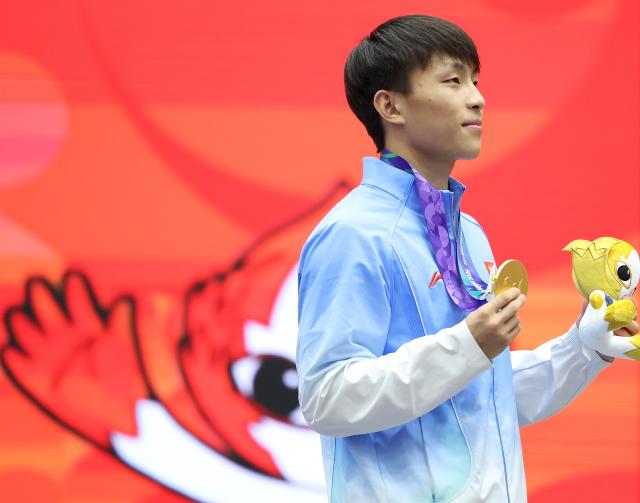 (260924) -- NAGOYA, Sept. 24, 2026 (Xinhua) -- Gold medalist Ou Jiaming of China reacts during the victory ceremony for the men's 56kg of Wushu at the 20th Asian Games Aichi-Nagoya 2026 in Nagoya, Japan, Sept. 24, 2026. (Xinhua/Long Lei)