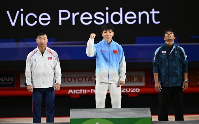 (260924) -- NAGOYA, Sept. 24, 2026 (Xinhua) -- Gold medalist Yang Yang (C) of China, silver medalist Pang Un Chol (L) of the Democratic People's Republic of Korea and bronze medalist Theerapong Silachai of Thailand react during the awarding ceremony for the men's 60kg of weightlifting at the 20th Asian Games Aichi-Nagoya 2026 in Nagoya, Japan, Sept. 24, 2026. (Xinhua/Yu Yang)