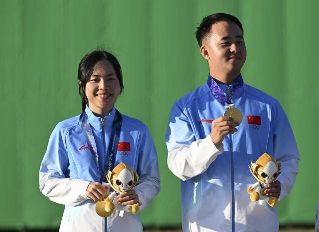 (260924) -- TOYOTA, Sept. 24, 2026 (Xinhua) -- Lyu Jianlin (R) and Jiang Yiting of team China pose during the awarding ceremony for the Skeet mixed team final of Shooting at the 20th Asian Games Aichi-Nagoya 2026 in Toyota of Aichi Prefecture, Japan, Sept. 24, 2026. (Xinhua/Liu Lei)