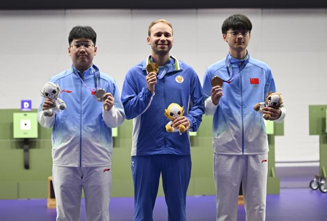 (260924) -- TOYOTA, Sept. 24, 2026 (Xinhua) -- Gold medalist Vladimir Svechnikov (C) of Uzbekistan, silver medalist Hu Kai (L) of China and bronze medalist Bu Shuaihang of China pose during the awarding ceremony for the 10m Air Pistol men individual of Shooting at the 20th Asian Games Aichi-Nagoya 2026 in Toyota of Aichi Prefecture, Japan, Sept. 24, 2026. (Xinhua/Liu Lei)