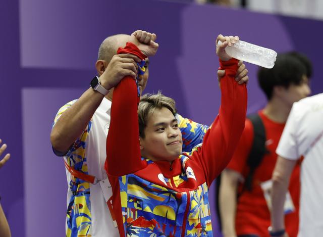 (260924) -- NAGOYA, Sept. 24, 2026 (Xinhua) -- Carlos Edriel Yulo (front) of the Philippines celebrates after the men's floor exercise final of Artistic Gymnastics at the 20th Asian Games Aichi-Nagoya 2026 in Nagoya, Japan, Sept. 24, 2026. (Xinhua/Wang Lili)