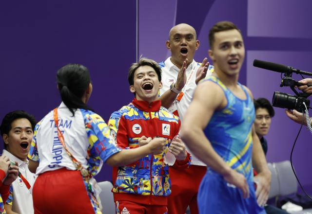 (260924) -- NAGOYA, Sept. 24, 2026 (Xinhua) -- Carlos Edriel Yulo (C) of the Philippines celebrates after the men's floor exercise final of Artistic Gymnastics at the 20th Asian Games Aichi-Nagoya 2026 in Nagoya, Japan, Sept. 24, 2026. (Xinhua/Wang Lili)