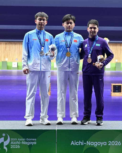 (260925) -- TOYOTA, Sept. 25, 2026 (Xinhua) -- Gold medalist Liu Yukun (C) of China, silver medalist Zhang Changhong (L) of China and bronze medalist Islam Satpayev of Kazakhstan pose during the victory ceremony for the 50m rifle 3 positions men individual final of shooting at the 20th Asian Games Aichi-Nagoya 2026 in Toyota of Aichi Prefecture, Japan, Sept. 25, 2026. (Xinhua/Liu Lei)